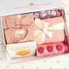 Adorable baby gift box featuring pink clothing, a puzzle book, and storage containers.
