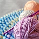 Vibrant yarn and crochet hook on textured fabric. Perfect for craft projects.
